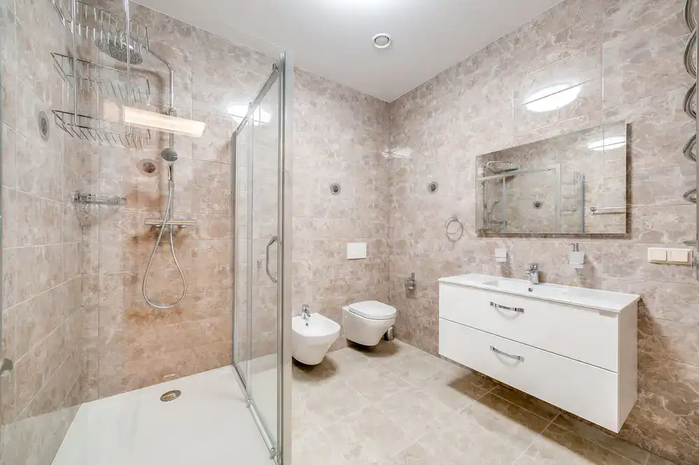 A bright modern bathroom suite showing a vanity and walk-in shower